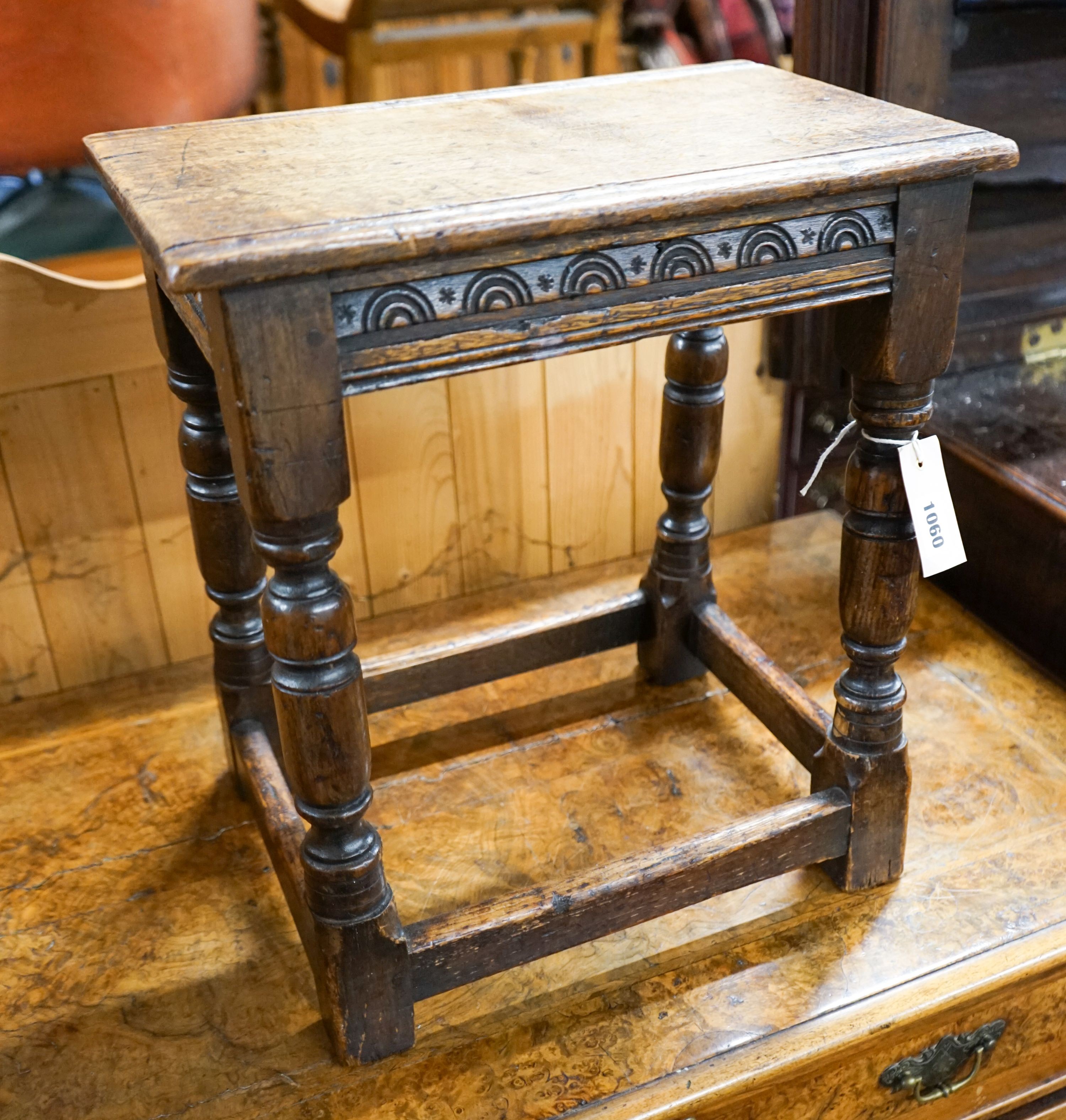 An 17th century style carved oak joint stool on turned supports, length 40cm, depth 25cm, height 45cm